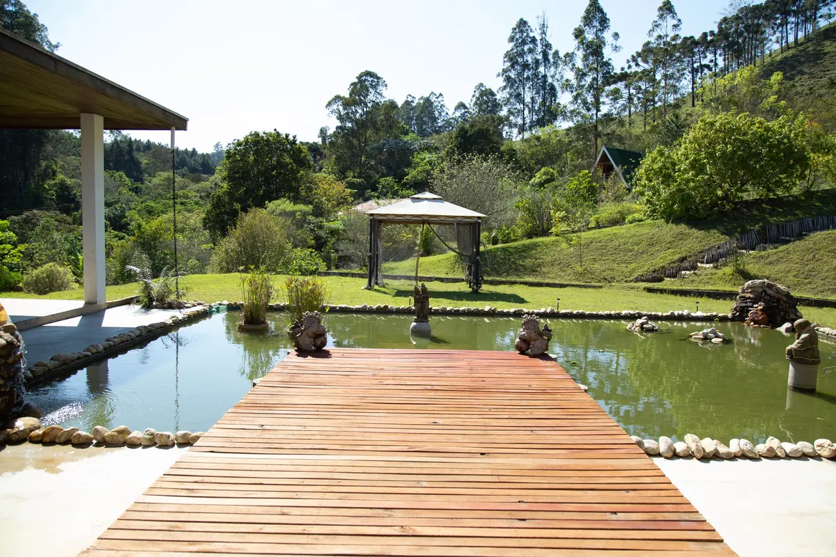 Deck e lago do Sítio Magia de Ser cercados por área verde